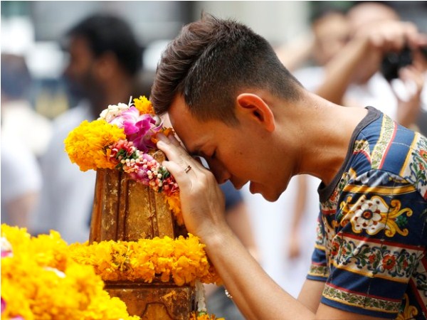 Homem faz oração nesta segunda-feira (24) no santuário de Erawan, na Tailândia, uma semana após atendado terrorista que matou 20 pessoas (Foto: AP Photo/Sakchai Lalit)