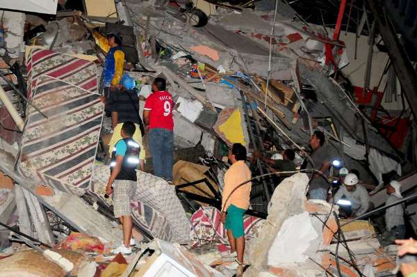 Grupo de pessoas busca sobreviventes nos escombros de um edifício em Manta, Equador (Foto: Reuters)