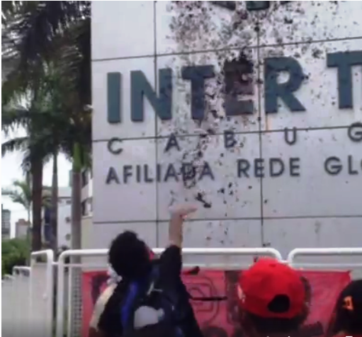 Manifestantes jogando estrume na fachada da Inter TV.
