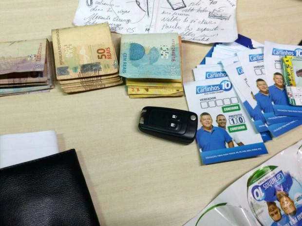 Dinheiro e "santinhos" foram apreendidos com dois homens em Tibau, RN (Foto: Divulgação/PM)