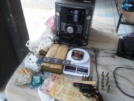 Arma, droga, munição, dinheiro e objetos apreendidos na casa do acusado